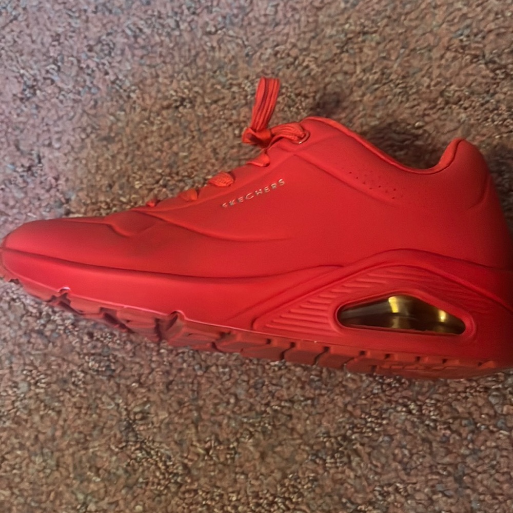 All red Skechers with gold whiting.